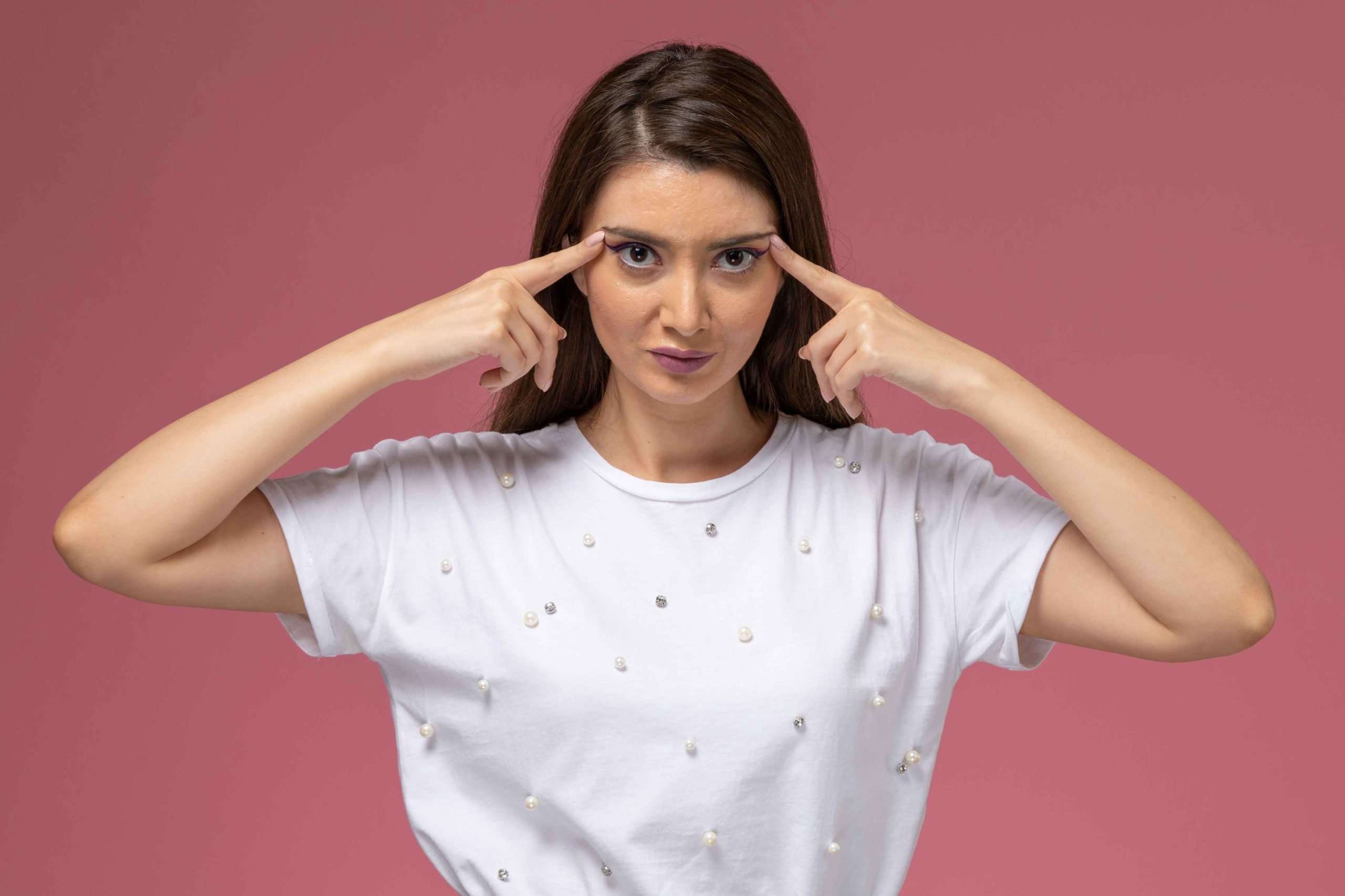 front-view-young-female-white-shirt-touching-her-temples-pink-wall-model-woman-pose (1)